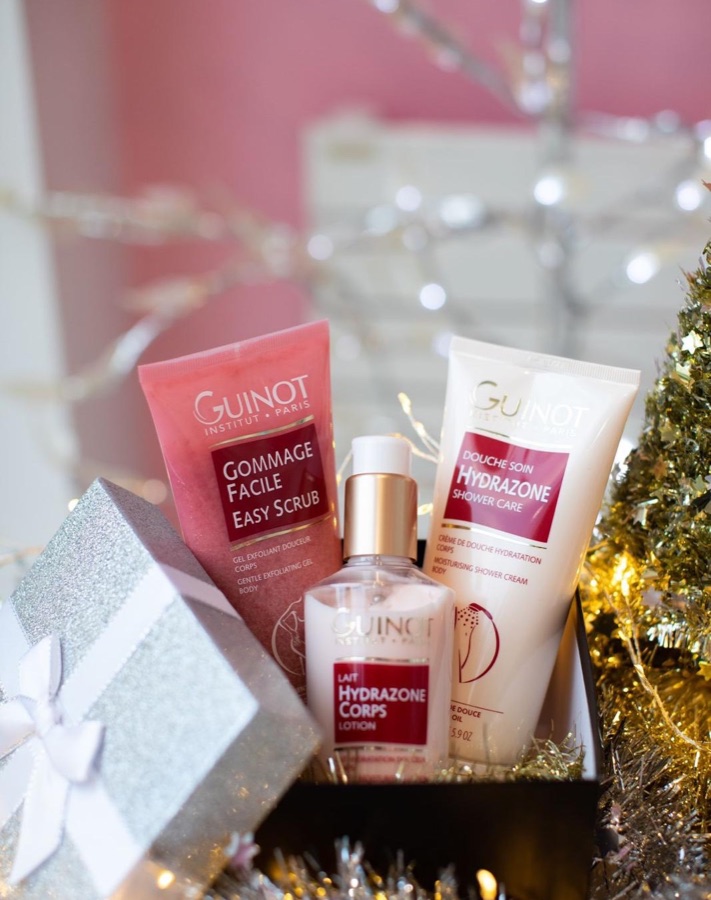Un coffret Guinot ouvert : gommage, lait et douche soin Hydrazone, dans un décor de fête