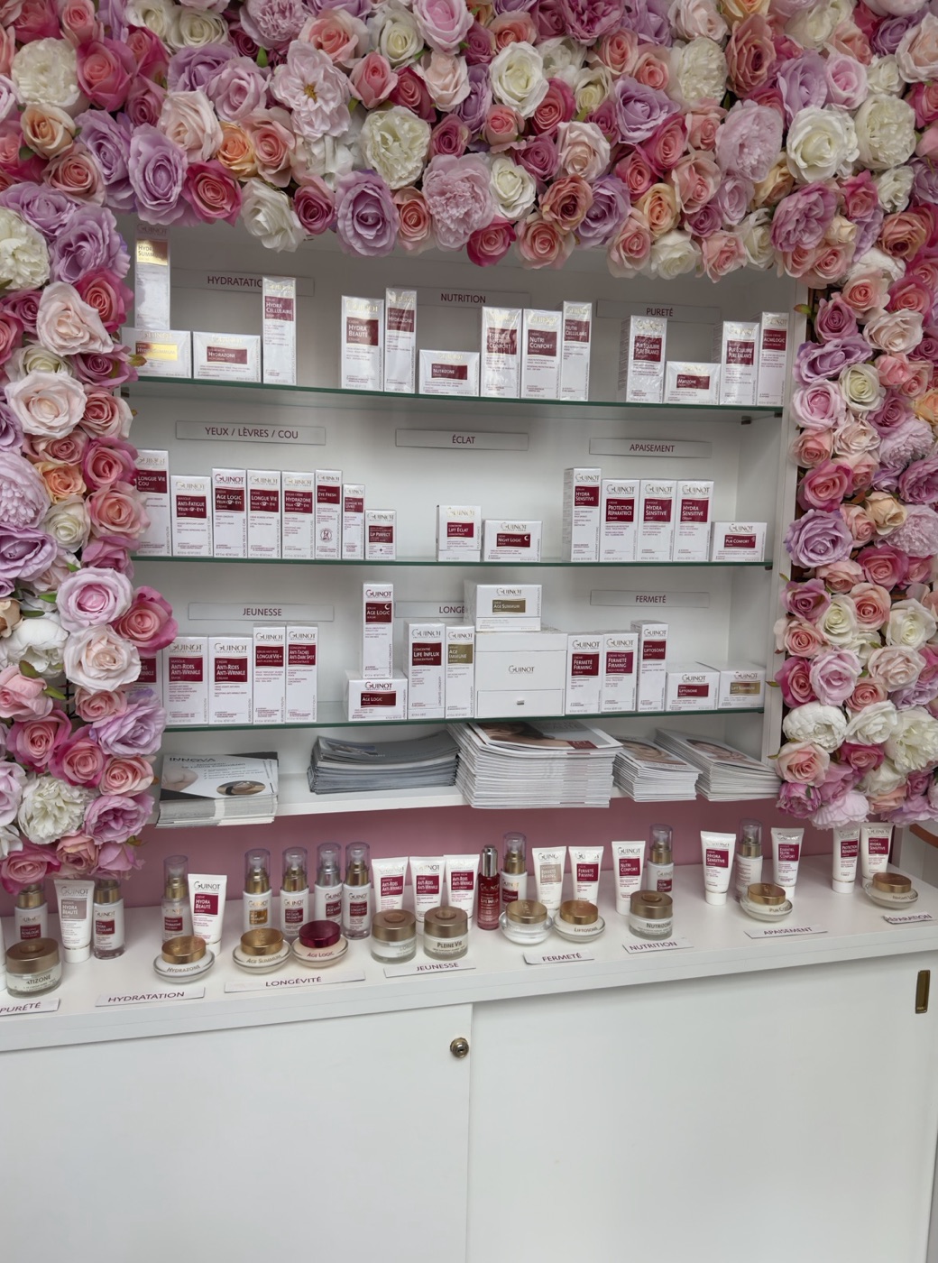 Le mur de présentoirs Guinot, le long du mur de fleurs